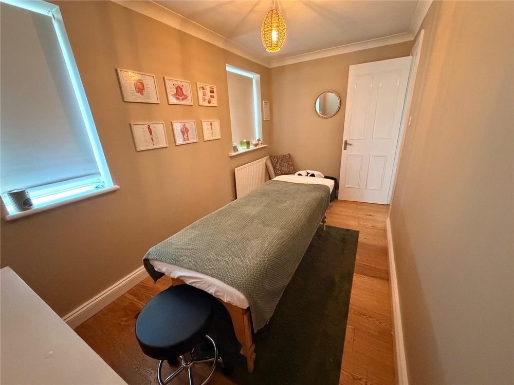 Treatment room seating area beside the massage table